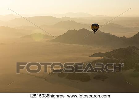 Stock Photograph - Hot air balloon ride over the sand dunes in the Namib Desert at sunrise; Sossusvlei, Hardap Region, Namibia. Fotosearch