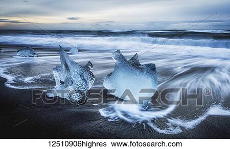 Jagged pieces of broken ice laying on the sandy shore at the edge of the ocean water; Iceland View Large Photo Image Stock Photograph - Jagged pieces of broken ice laying on the sandy shore at the edge of the ocean water; Iceland. Fotosearch