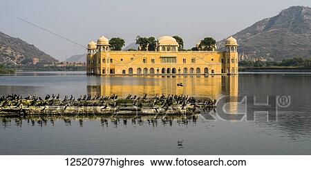 Stock Photograph - Jal Mahal Palace, made of red sandstone, sitting submerged in Man Sagar Lake; Jaipur, Rajasthan, India. Fotosearch