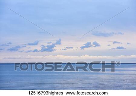 Stock Photograph - Lake Ontario at magic hour, a seascape with clouds; Ontario, Canada. Fotosearch