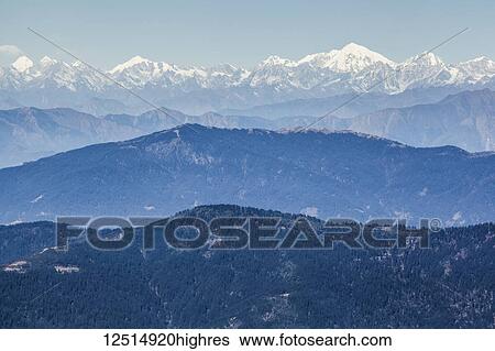 Stock Photograph - Layers of mountains in the Himalayas with snow-capped peaks in the distance; Nepal. Fotosearch
