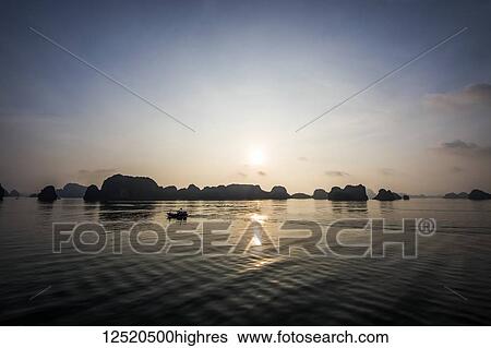 Limestone karsts and isles of Ha Long Bay at sunset; Quang Ninh, Vietnam View Large Photo Image Stock Photograph - Limestone karsts and isles of Ha Long Bay at sunset; Quang Ninh, Vietnam. Fotosearch