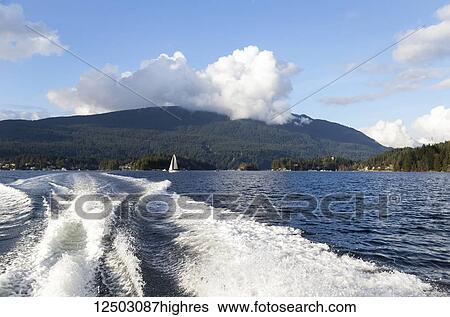 Looking back at the mountain range and city as the boat heads further into Deep Cove and the park at Indian Arm, a popular day trip for Vancouver city residents and tourists; Vancouver, British Columbia, Canada View Large Photo Image Stock Photograph - Looking back at the mountain range and city as the boat heads further into Deep Cove and the park at Indian Arm, a popular day trip for Vancouver city residents and tourists; Vancouver, British Columbia, Canada. Fotosearch