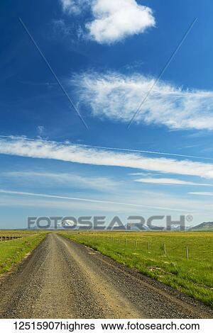 Stock Photograph - Looking down gravel road to Hekla volcano in the distance; Iceland. Fotosearch