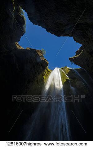 Stock Photograph - Looking up to a small waterfall in large hole near Seljalandsfoss; Iceland. Fotosearch