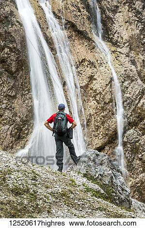 Male hiker on rocky slope overlooking cliff waterfalls; Grainau, Bavaria, Germany View Large Photo Image Stock Photograph - Male hiker on rocky slope overlooking cliff waterfalls; Grainau, Bavaria, Germany. Fotosearch