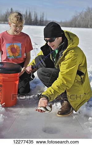 Man shows his catch while ice fishing on Matanuska Lake in the Matanuska Valley north of Anchorage, Southcentral Alaska, winter View Large Photo Image Stock Photography - Man shows his catch while ice fishing on Matanuska Lake in the Matanuska Valley north of Anchorage, Southcentral Alaska, winter. Fotosearch