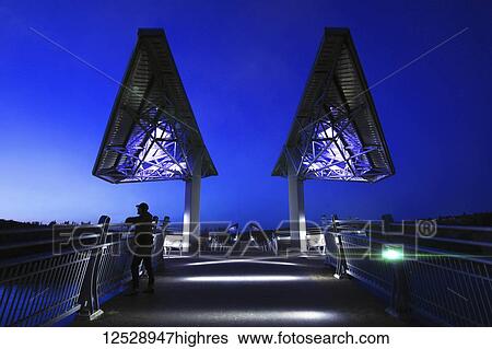 Man standing on Terwillegar Park bridge at dusk; Edmonton, Alberta, Canada View Large Photo Image Stock Photograph - Man standing on Terwillegar Park bridge at dusk; Edmonton, Alberta, Canada. Fotosearch