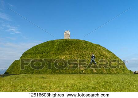 Man walking up Thufa grassy dome with fish drying house on top (art installation by Olof Nordal); Reykjavik, Iceland View Large Photo Image Stock Photograph - Man walking up Thufa grassy dome with fish drying house on top (art installation by Olof Nordal); Reykjavik, Iceland. Fotosearch