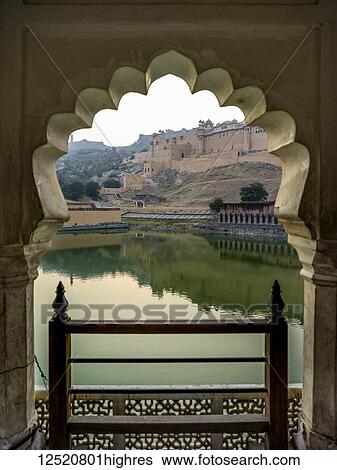 Stock Photograph - Maota Lake in front of Amer Fort viewed through a scalloped archway; Jaipur, Rajasthan, India. Fotosearch