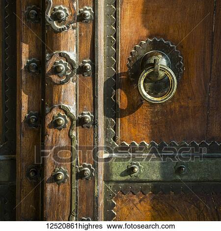 Stock Photograph - Metal decorative details on a wooden door, Amer Fort; Jaipur, Rajasthan, India. Fotosearch