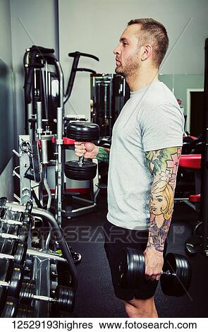 Stock Photograph - Mid adult man working out at a fitness facility; Spruce Grove, Alberta, Canada. Fotosearch