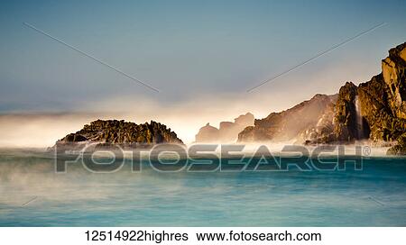 Stock Photograph - Mist over the turquoise water along the rugged coastline; Big Sur, California, United States of America. Fotosearch