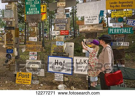 Mother and daughter explore the Signpost Forest, Watson Lake, Yukon Territory, Canada, summer View Large Photo Image Stock Image - Mother and daughter explore the Signpost Forest, Watson Lake, Yukon Territory, Canada, summer. Fotosearch