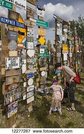Mother and daughter explore the Signpost Forest, Watson Lake, Yukon Territory, Canada, summer View Large Photo Image Stock Photo - Mother and daughter explore the Signpost Forest, Watson Lake, Yukon Territory, Canada, summer. Fotosearch