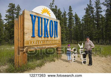Mother and daughter stand next to a Welcome and Yukon sign, Yukon Territory, Canada, summer View Large Photo Image Stock Image - Mother and daughter stand next to a Welcome and Yukon sign, Yukon Territory, Canada, summer. Fotosearch