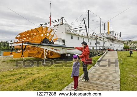 Mother and daughter stand on a boardwalk looking at the SS Klondike, Whitehorse, Yukon Territory, Canada, summer View Large Photo Image Stock Photo - Mother and daughter stand on a boardwalk looking at the SS Klondike, Whitehorse, Yukon Territory, Canada, summer. Fotosearch
