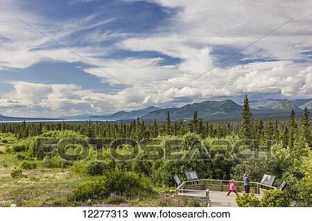 Stock Image - Mother and daughter view scenery from a platform along the Alaska Highway south of Kluane Lake, Yukon Territory, Canada, summer. Fotosearch