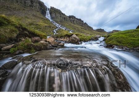 Stock Photograph - Motion blur of flowing water at a waterfall near Djupavik; West Fjords, Iceland. Fotosearch