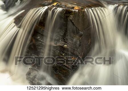 Stock Photograph - Motion blur of water flowing over rocks in Kings Brook, near Sleepy Cove, Shubenacadie Grand Lake; Nova Scotia, Canada. Fotosearch