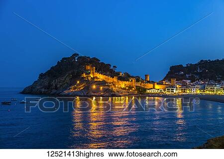 Stock Photograph - Night view from Tossa de Mar of Castell de Tossa, which was built in 1187; Tossa de Mar, Girona, Spain. Fotosearch