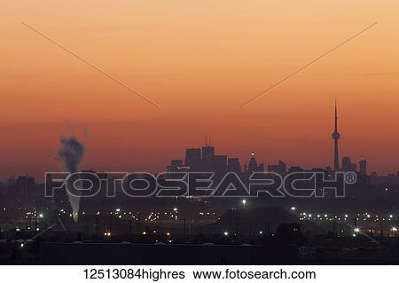 Stock Photograph - Northern Mississauga in the foreground and the skyline of the city of Toronto just before sunrise; Mississauga, Ontario, Canada. Fotosearch