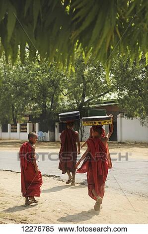 Novice buddhist monks carrying food on their heads; Bagan, Myanmar View Large Photo Image Stock Photography - Novice buddhist monks carrying food on their heads; Bagan, Myanmar. Fotosearch