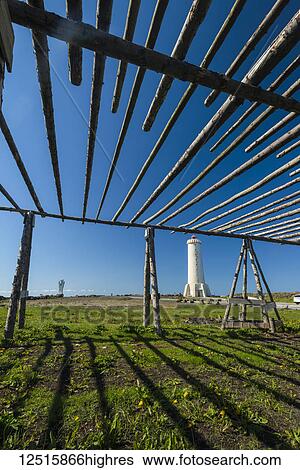 Stock Photograph - Old fish drying racks next to a lighthouse; Akranes, Iceland. Fotosearch