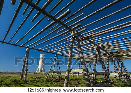 Stock Photograph - Old fish drying racks next to a lighthouse; Akranes, Iceland. Fotosearch