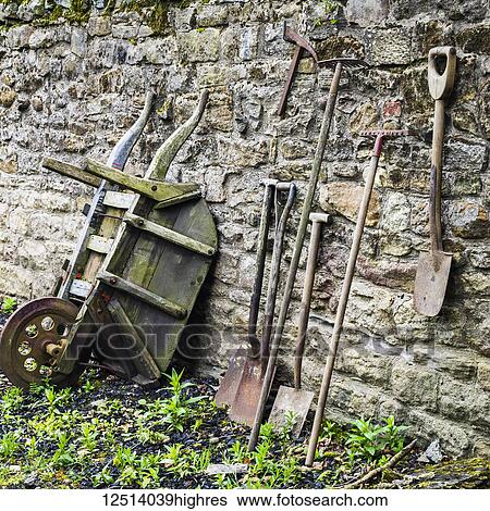 Old garden tools leaning up against a weathered stone wall, Open Air Museum, England View Large Photo Image Stock Photograph - Old garden tools leaning up against a weathered stone wall, Open Air Museum, England. Fotosearch