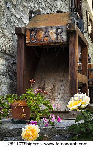 Stock Photograph - Old wooden bar equipment with flowers in pots, Dolonne, near Courmayeur; Aosta Valley, Italy. Fotosearch