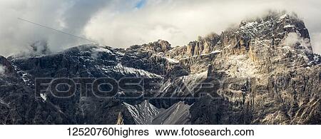 Stock Photograph - Panorama of mountain range with cloud cover; Sesto, Bolzano, Italy. Fotosearch