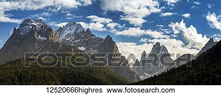 Panorama of rugged mountain range, snow-capped peaks with blue sky and cloud; Sesto, Bolzano, Italy View Large Photo Image Stock Photograph - Panorama of rugged mountain range, snow-capped peaks with blue sky and cloud; Sesto, Bolzano, Italy. Fotosearch