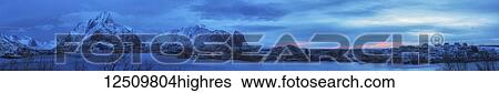 Panoramic of the rugged mountains along the coastline of Norway at sunrise under a blue hue; Svolvar, Lofoten Islands, Nordland, Norway View Large Photo Image Stock Photograph - Panoramic of the rugged mountains along the coastline of Norway at sunrise under a blue hue; Svolvar, Lofoten Islands, Nordland, Norway. Fotosearch