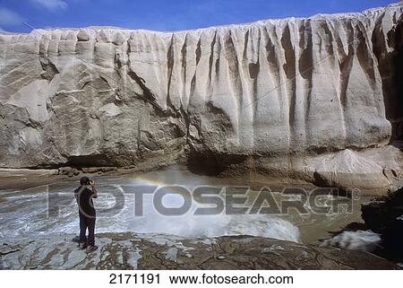 Stock Image - Person Views A Volcanic Ash Wall Above The Okak Waterfalls Of Lethe River In The Valley Of 10, 000 Smokes, Katmai National Park, Alaska. Fotosearch