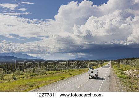 Pick up camper driving on the Alaska Highway with stormy clouds overhead, west of Whitehorse, Yukon Territory, Canada, Summer View Large Photo Image Stock Image - Pick up camper driving on the Alaska Highway with stormy clouds overhead, west of Whitehorse, Yukon Territory, Canada, Summer . Fotosearch