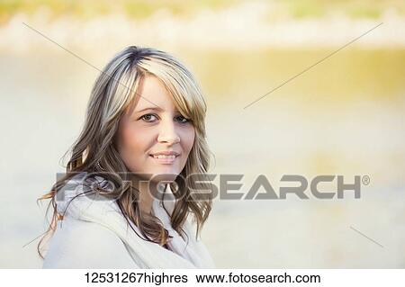 Portrait of a beautiful mature woman with blond hair in a city park with autumn colours in the background reflected on tranquil water; Edmonton, Alberta, Canada View Large Photo Image Stock Photograph - Portrait of a beautiful mature woman with blond hair in a city park with autumn colours in the background reflected on tranquil water; Edmonton, Alberta, Canada. Fotosearch