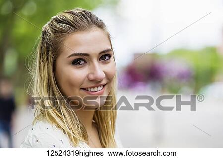 Stock Photograph - Portrait of a beautiful young woman on a university campus with the background blown out; Edmonton, Alberta, Canada. Fotosearch