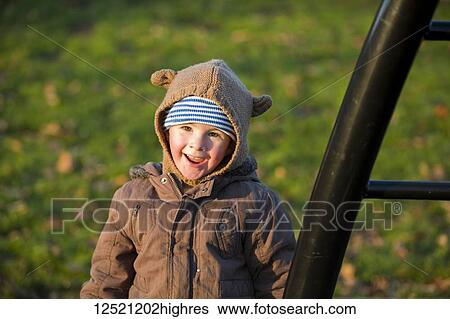 Stock Photograph - Portrait of a young boy playing on playground equipment; Langley, British Columbia, Canada. Fotosearch