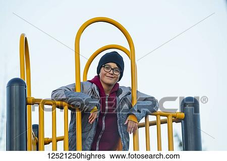 Stock Photograph - Portrait of a young boy playing on playground equipment; Langley, British Columbia, Canada. Fotosearch