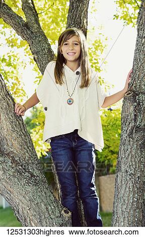 Portrait of a young girl standing in a tree in a park in autumn; Edmonton, Alberta, Canada View Large Photo Image Stock Photograph - Portrait of a young girl standing in a tree in a park in autumn; Edmonton, Alberta, Canada. Fotosearch