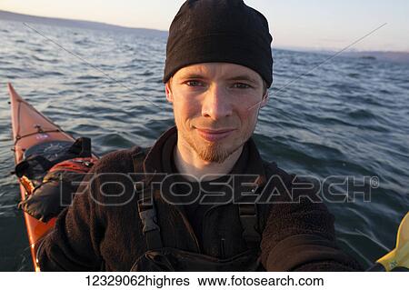 Portrait of a young man in a kayak on the water at sunset, Kachemak Bay State Park; Alaska, United States of America View Large Photo Image Stock Photograph - Portrait of a young man in a kayak on the water at sunset, Kachemak Bay State Park; Alaska, United States of America. Fotosearch