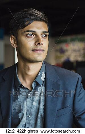 Stock Photograph - Portrait of a young millennial businessman in the workplace; Sherwood Park, Alberta, Canada. Fotosearch