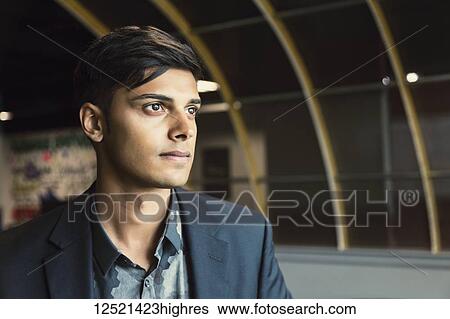 Stock Photograph - Portrait of a young millennial businessman in the workplace; Sherwood Park, Alberta, Canada. Fotosearch