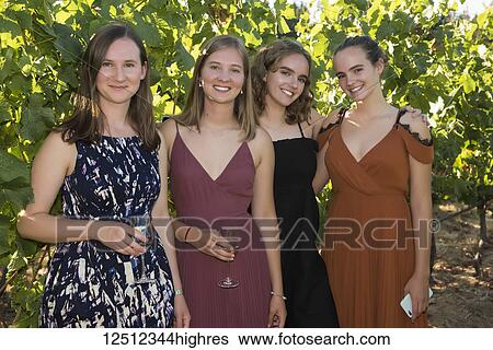 Portrait of four young women dressed in formal wear and holding glasses with drinks; Cobble Hill, British Columbia, Canada View Large Photo Image Stock Photograph - Portrait of four young women dressed in formal wear and holding glasses with drinks; Cobble Hill, British Columbia, Canada. Fotosearch