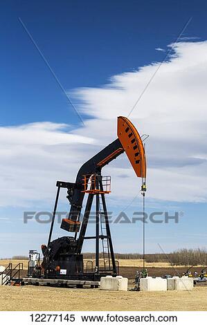 Pumpjack with blue sky and clouds; Alberta, Canada View Large Photo Image Stock Photography - Pumpjack with blue sky and clouds; Alberta, Canada. Fotosearch
