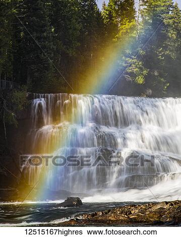 Stock Photograph - Rainbow over a waterfall in Wells Gray Provincial Park; Thompson-Nicola Regional District, British Columbia, Canada. Fotosearch
