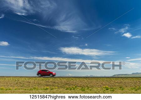 Red car driving on open road near Hella with Hekla volcano in the distance; Iceland View Large Photo Image Stock Photograph - Red car driving on open road near Hella with Hekla volcano in the distance; Iceland. Fotosearch