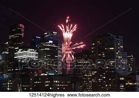 Stock Photograph - Red fireworks in the night sky in front of the CN tower; Toronto, Ontario, Canada. Fotosearch