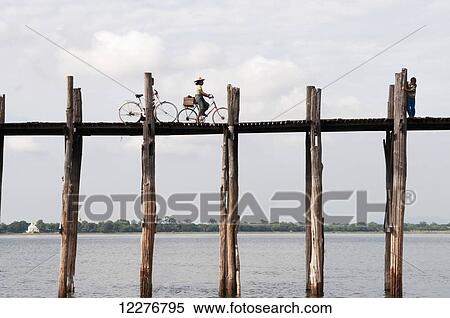 Riding bicycles on an elevated wooden bridge over Taungthaman Lake; Amarapura, Myanmar View Large Photo Image Stock Photography - Riding bicycles on an elevated wooden bridge over Taungthaman Lake; Amarapura, Myanmar. Fotosearch
